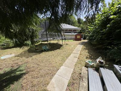 Pelouse débroussaillée et tondue autour du trampoline et de la cabane des enfants — après