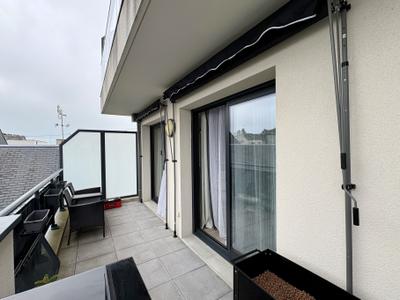 Store banne installé sur un balcon à Granville, fixé par barres de tension sans perçage de la façade