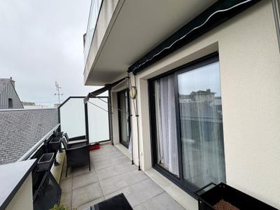 Deux stores bannes montés le long d'un balcon d'appartement, fixation par tension entre sol et plafond